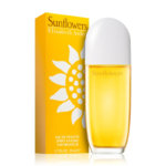 Une boîte jaune du parfum « Sunflowers » d'Elizabeth Arden se trouve à côté d'un flacon jaune assorti muni d'un bouchon blanc. La boîte est ornée d'un motif représentant un tournesol et comporte les détails du produit en lettres blanches. Dakar