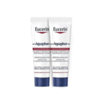 Deux tubes blancs de pommade cicatrisante Eucerin Aquaphor avec un texte bleu et rouge se tiennent debout côte à côte sur un fond blanc. Dakar
