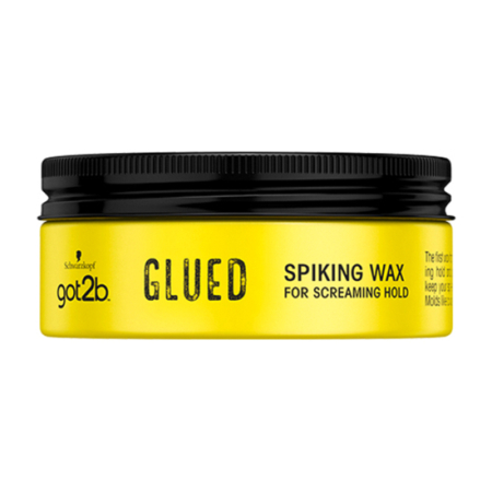 Un pot jaune de cire « got2b Glued Spiking Wax for Screaming Hold » de Schwarzkopf, muni d'un couvercle noir et d'une inscription en noir bien visible sur le devant. Dakar