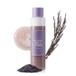 Un flacon de "I'm From Lotion Tonique au Riz Adoucissante et Hydratante 150 ml (Copie)" avec un bouchon et une étiquette en lavande est représenté à côté de riz noir, d'une brindille de lavande et d'un échantillon sur un fond blanc. Dakar