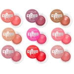 Neuf pots de « CloudTopia Blush Crème Mat Lèvres Et Joues » de Maybelline New York, déclinés en différentes teintes, sont disposés en une grille de 3 × 3, chacun avec le couvercle légèrement entrouvert pour laisser entrevoir la couleur du fard à joues à l'intérieur. Dakar