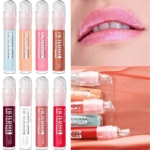 Dix tubes de « Lifter Gel Huile Pour Les Lèvres » de Maybelline New York, dans des teintes variées, sont présentés, accompagnés d'images mettant en valeur des lèvres brillantes et d'un gros plan du gloss appliqué sur une surface couleur pêche. Dakar