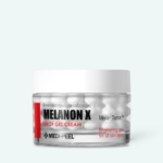 Un pot transparent de Medi Peel Crème Gel Rajeunissant et Illuminant Melanon X Drop 50 ml, bouchon blanc, texte noir et rouge, présente des formes de capsule. L'étiquette indique "Soin éclaircissant pour tous les types de peau. Dakar