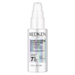 Un flacon de 45 ml de « My Redken Acidic Bonding Concentrate » de Redken, muni d'un distributeur à pompe, dans un emballage blanc et doté d'une étiquette avant irisée indiquant les informations sur le produit. Dakar
