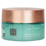 Un pot vert avec un couvercle en bronze métallique étiqueté "The Ritual of Karma Softening Body Scrub" contenant du sel et des minéraux marins. Le texte du produit est rédigé en anglais et en français. Dakar