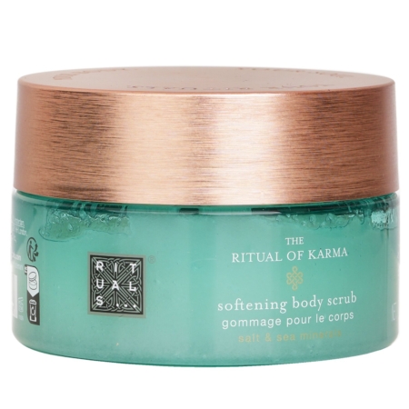 Un pot vert avec un couvercle en bronze métallique étiqueté "The Ritual of Karma Softening Body Scrub" contenant du sel et des minéraux marins. Le texte du produit est rédigé en anglais et en français. Dakar