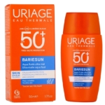 Un flacon et une boîte orange de crème solaire Uriage Bariesun SPF 50+, étiquetée pour une très haute protection et un fluide aqua ultra-mat. L'emballage comporte un texte bleu et blanc et diverses informations sur le produit. Dakar