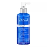 Un flacon bleu de 100 ml de lotion capillaire Uriage DS Antipelliculaire Régulatrice pour cuir chevelu irrité, sans rinçage, muni d'une pompe blanche, avec des détails argentés et blancs, et un étiquetage bilingue. Dakar