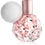 Un flacon de parfum rose à facettes, muni d'un bouchon métallique couleur or rose et d'un pompon blanc duveteux fixé au col. Le mot « ARIANA » est visible sur le col du flacon. Dakar
