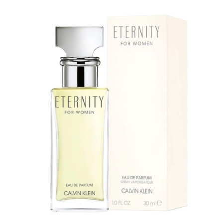 Un flacon de 100 ml d'Eau de Parfum Femme Calvin Klein Eternity trône devant son coffret de couleur crème, tous deux ornés d'un lettrage minimaliste noir et argenté. Le flacon contient un parfum jaune pâle. Dakar