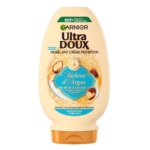 Un flacon d'après-shampoing Garnier Ultra Doux Richesse d'Argan, à la crème d'amande et à l'huile d'argan du Maroc, pour les cheveux secs à très secs. L'emballage est de couleur crème, rehaussé de touches de vert et d'or. Dakar