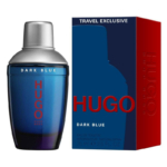 Un flacon d'eau de toilette Hugo Boss Dark Blue posé à côté de son coffret assorti bleu et rouge portant la mention « Travel Exclusive ». Le flacon est bleu foncé, avec un bouchon argenté et le logo HUGO en rouge. Dakar
