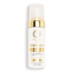 Un flacon blanc muni d'une pompe dorée et de détails dorés, portant l'étiquette « MUC Natur » ornée de motifs décoratifs, contient le produit « Musc Intime Monoï Oriental La rayonnante Mousse Nettoyante Intime » en format de 150 ml. L'étiquette comporte un texte en français et indique que le produit permet 300 utilisations. Dakar