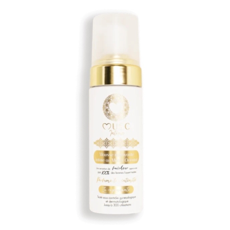 Un flacon blanc muni d'une pompe dorée et de détails dorés, portant l'étiquette « MUC Natur » ornée de motifs décoratifs, contient le produit « Musc Intime Monoï Oriental La rayonnante Mousse Nettoyante Intime » en format de 150 ml. L'étiquette comporte un texte en français et indique que le produit permet 300 utilisations. Dakar