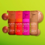 Quatre huiles pour le corps Nyx Fat Oil « Body Huile Corps Hydratante 24h Effet Glow » de 70 ml — Caramel Mami, Juicy Boo, Suga Baddie et Coconut Cutie — sont disposées sur un fond vert parsemé d'échantillons chatoyants, qui mettent en valeur leur éclat radieux. Dakar