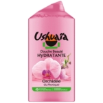 Un flacon rose de gel douche hydratant et embellissant Ushuaïa, orné d'images d'orchidées roses et d'une inscription en vert indiquant qu'il est parfumé à l'orchidée mexicaine. L'emballage est partiellement transparent et comporte les informations sur le produit en français. Dakar