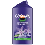 Un flacon violet de gel douche Ushuaïa portant la mention « Douche Massage Délassante », orné de fleurs d'ylang et de touches de vert, indiquant la présence d'huile essentielle d'ylang de Madagascar. Dakar