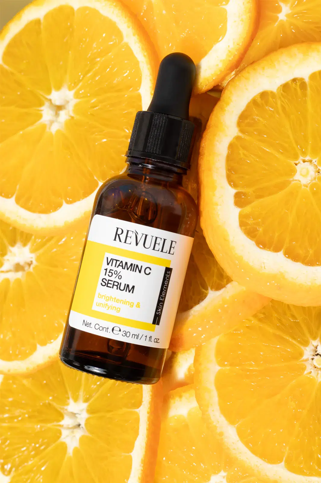 Le sérum Revuele à la vitamine C 15 % « Sérum Illuminateur Teint Unifié » (30 ml), muni d'un bouchon compte-gouttes, est déposé sur des tranches d'orange, mettant ainsi en valeur ses propriétés éclaircissantes et unifiantes. Dakar